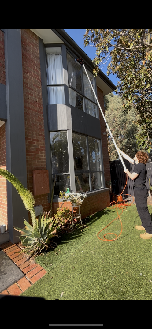 Justin using a water-fed pole to clean upper storey windows on a Melbourne home